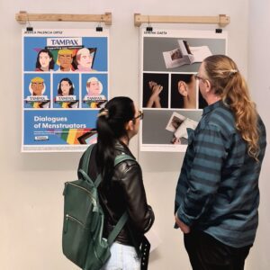 two students viewing artwork about menstruation and the body