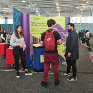 DGHE attends University Exhibitions in London, people gather around our table.