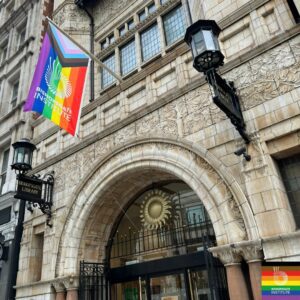 Bishopsgate Institute building with a LGBTQAI+ flag hanging from their main door.